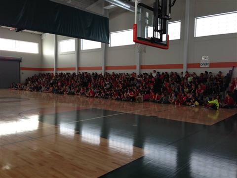 A large group of people sitting on the court.